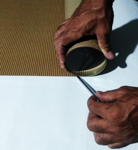 Foto da lente sobre o papelão e o marcando com uma caneta